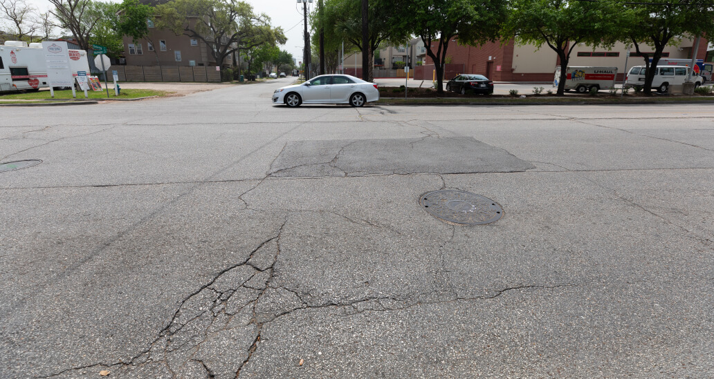 Washington Avenue at Detering Street showing asphalt cracks in the road.