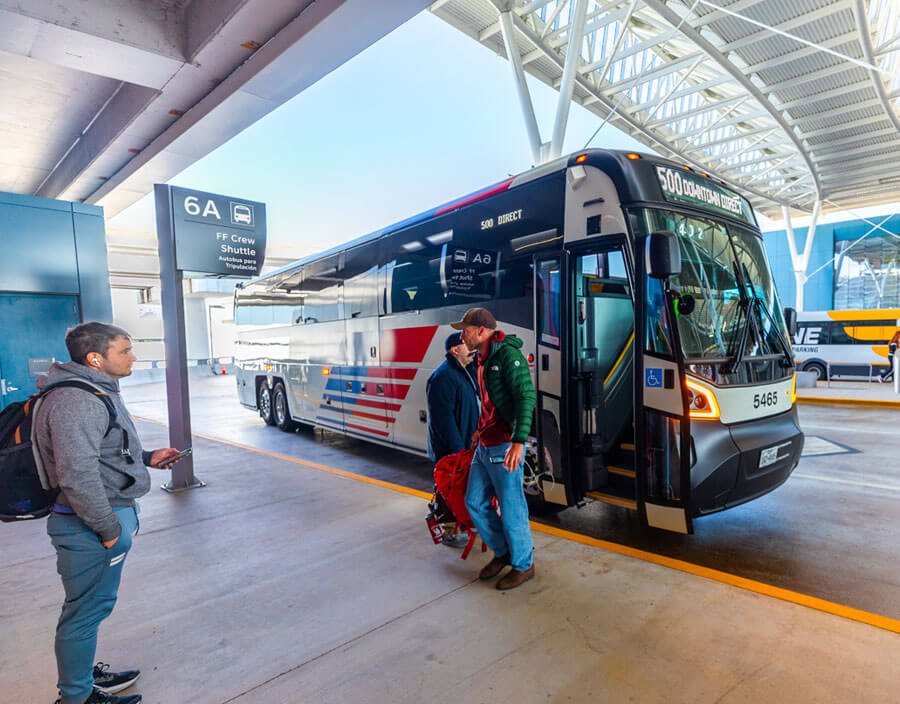 Customer getting on and off the 500 Downtown Direct bus at the airport stop in Terminal E.